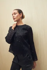 Blusa negra de manga larga con cuello redondo y lentejuelas a tono.