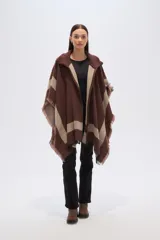 Poncho de tejido grueso, color negro y gris, con diseño de franjas diagonales y cuello alto con cierre. Presenta terminaciones con flecos.