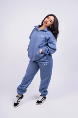 Pantalón de jogging color beige con cintura elástica y logo estampado en blanco en el muslo.