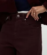 Pantalón modelo carrot de sarga, con cintura alta, pretina con presillas, cierre frontal con botón y cremallera, y bolsillos funcionales. Presenta un calce holgado en la cadera que se estrecha hacia el bajo.