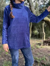 Polerón azul de plush de algodón con cuello alto, mangas largas y corte holgado. Cuenta con tajos laterales y espalda más larga. Tiene aperturas laterales ocultas para amamantar.