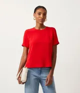 Blusa de tejido plano color azul marino, con cuello redondo, mangas cortas y cierre trasero tipo gota con botón.
