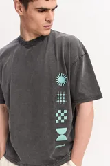 Remera de algodón marca Mistral, de corte boxy manga corta con efecto acid wash y estampas geométricas en color celeste dispuestas verticalmente sobre el frente.