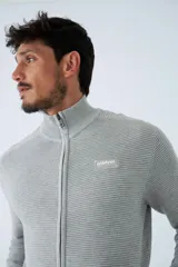 Campera tejida de algodón en color bordó, con cierre frontal completo, cuello alto y logo bordado en el pecho.