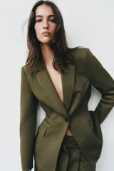Blazer verde militar entallado con cuello de solapa, manga larga, cierre frontal de un botón y bolsillos con solapa.