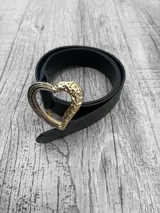 Cinto negro con hebilla dorada en forma de corazón.