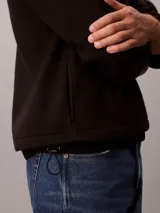 Buzo polar Calvin Klein de textura suave, con cuello alto y cierre de media cremallera frontal. Presenta un diseño de manga larga con corte regular y logo de la marca sutilmente bordado en el pecho.