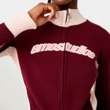 Campera de punto oversize color bordó con detalles en rosado, cuello alto, cierre frontal completo y diseño bordado en el pecho.