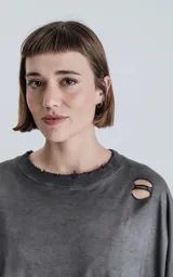 Remera de manga corta, calce extra oversize, color gris oscuro con efecto gastado/degradado. Presenta roturas y detalles deshilachados en cuello, hombros y puños.