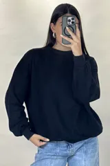 Buzo de cuello redondo, corte oversize, con mangas largas y puños elásticos.