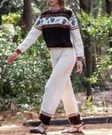 Pantalón jogger de punto color blanco marfil, confeccionado en lana merino, con tiro alto, cintura elástica y diseño con bloque de color marrón y detalles geométricos en el bajo.