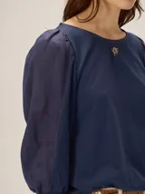 Blusa de diseño combinado con cuerpo delantero y espalda de algodón negro, y mangas abullonadas tres cuartos de lino en color beige con puños elásticos negros.