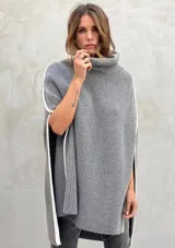 Poncho gris de lana con cuello alto y aberturas laterales con ribete blanco.