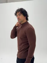 Polera de tejido de punto color marrón, con cuello alto y mangas largas con puños acanalados.