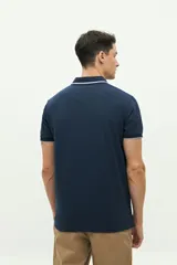 Remera polo gris con cuello y mangas con borde blanco, logo bordado en el pecho y corte regular. Confeccionada en algodón y spandex.