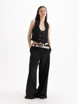 Pantalón de vestir tiro alto color celeste, de corte wide leg y largo hasta el suelo, con bolsillos delanteros decorados con volados tableados y bolsillos ojal en la espalda.