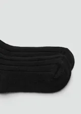 Calcetines de punto acanalado en color negro, con diseño clásico de caña media.