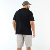 Camiseta de manga corta y cuello redondo en color negro. Presenta un estampado fotográfico central en blanco y negro con temática de ciclismo y tipografía decorativa.