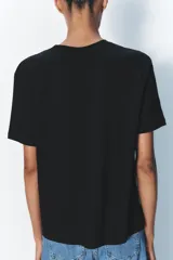 Camiseta de algodón color negro, con cuello redondo, manga corta y corte regular fit.