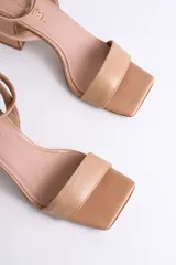 Sandalias plateadas de cuero con pulsera al tobillo y tacón cuadrado.