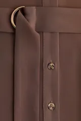 Vestido midi marrón de estilo camisero, con cuello, cierre frontal de botones, hombros caídos y mangas largas. Incluye un cinturón de tela con hebilla metálica de anillas en D.