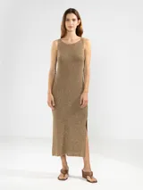 Vestido midi sin mangas tejido en punto jersey con hilo Lurex que aporta un brillo sutil. Presenta escote bote redondeado y aberturas laterales en el ruedo.