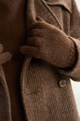 Saco de lana color tostado, con solapa, doble abotonadura, bolsillos, canesú y charreteras. Prenda de uso diario.