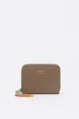 Billetera compacta de nylon color beige, con cierre de cremallera perimetral y tirador decorativo con cordón. Presenta el logo metálico de la marca en el frente.