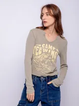 Remera de manga larga confeccionada en tela tipo waffle, con cuello redondo y estampa desgastada en el frente.