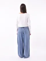 Remera de manga larga color beige, con cuello redondo y estampado frontal que dice "Magic is something you make" en color lila.