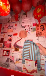 Polera de cuello alto y manga larga, con diseño ajustado al cuerpo y estampado de rayas verticales y horizontales en contraste de color rojo y negro.