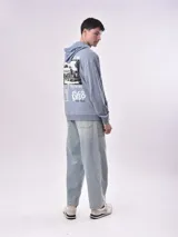 Buzo canguro celeste con capucha y cordón ajustable. Estampado frontal con la frase "Let's start rolling. Forget the rules". Corte holgado con puños y cintura acanalados.