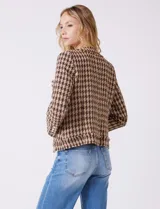 Chaqueta de tweed marca Nanette, color marrón y beige con estampado pata de gallo. Cuello redondo, abertura central, bolsillos delanteros y puños con botones perlados. Terminación desflecada y forro interno.