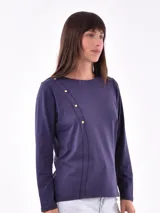 Remera de manga larga color azul oscuro, con cuello redondo y detalle de costura diagonal con botones dorados en el frente.