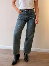 Jeans mom fit de tiro alto y pierna relajada, en tono denim envejecido con matices gris-azulados. Presenta un diseño exclusivo con efecto de pinceladas y salpicaduras artísticas, bolsillos delanteros y traseros, y costuras reforzadas.