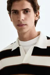 Sweater de punto suave con diseño a rayas horizontales en blanco, negro y marrón, cuello polo con abertura en V y manga larga con puños acanalados.