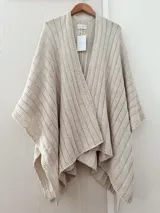 Ruana tejida en punto jersey con hilo de algodón y lurex, de diseño abierto y caída fluida.