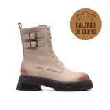 Bota de cuero color beige con suela track negra, cordones y hebillas decorativas.