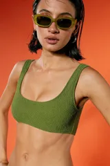 Top de bikini verde militar con textura arrugada, escote amplio y breteles fijos. Incluye bombacha vedetina con frente en V.
