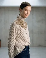 Camisa de manga larga con diseño de rayas verticales, confeccionada en algodón. Presenta un canesú superior en lana con estampado de cuadros en tonos tierra, cuello alto con volados y cierre frontal con botones.