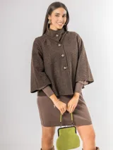 Chaqueta tipo capa de lana bouclé en color marrón, con cuello mao y cierre frontal de botones grandes. Presenta mangas tres cuartos con puños ajustados de tejido acanalado.