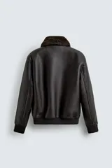 Cazadora de corte relajado confeccionada en tejido efecto piel color marrón oscuro. Presenta cuello de solapa desmontable en tejido efecto pelo, bolsillos frontales de plastrón con solapa, cierre frontal de cremallera y acabados en rib en puños y bajo.