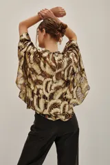 Camisa de lurex con estampado animal print en tonos dorados y marrones, con escote en V profundo y mangas amplias con volados. Incluye forro interior.