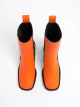 Botín de piel negra, estilo Chelsea, con elásticos laterales y punta cuadrada. Presenta un tacón ancho y alto.