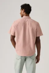 Camisa de manga corta color rosado, con cuello abotonado y cierre frontal con botones. Cuenta con sutil bordado del logo en el pecho.