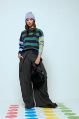 Sweater de punto con diseño de franjas horizontales multicolores en tonos verde, azul marino, rojo y celeste. Presenta cuello redondo y mangas largas con puños acanalados.