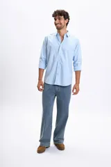 Camisa de corte casual con diseño de rayas verticales finas en color azul y blanco, cuello clásico y mangas largas.