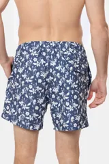 Short de baño clásico con estampado de flores blancas sobre fondo azul marino, cintura elástica con cordón ajustable, dos bolsillos laterales y suspensor de malla fina.