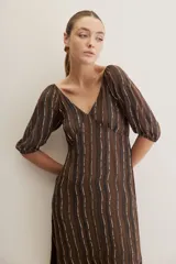 Vestido largo celeste con estampado botánico en tonos marrones, escote en V, mangas cortas abullonadas y falda con volado en el bajo.