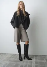 Bota de caña alta confeccionada en piel bovina, con diseño de punta fina y tacón de bloque. Presenta un acabado liso y cierre lateral.